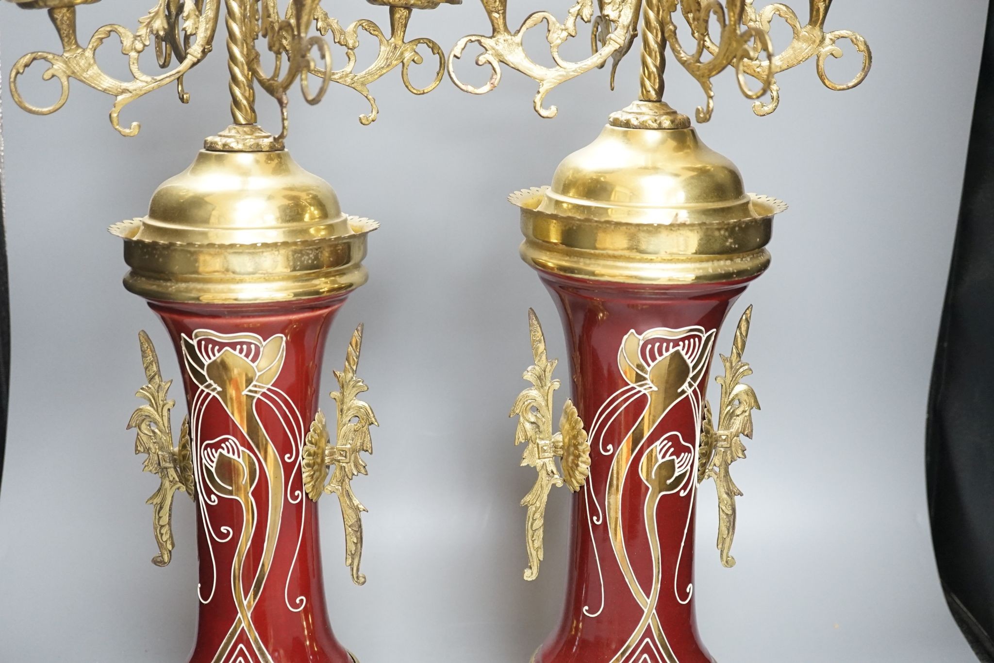 A pair of large brass and ceramic mounted candelabra, 64.5 cms high.